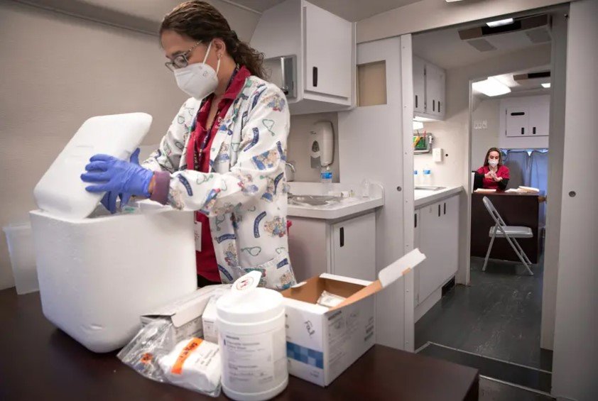 Shirley Cortez, left, prepares flu shots while Janel Allen applies hand sanitizer inside the mobile unit in front of Falfurrias High School on Nov. 13, 2020.